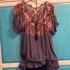 Outfit, stretch capris and boho top and pierced hoop earrings.